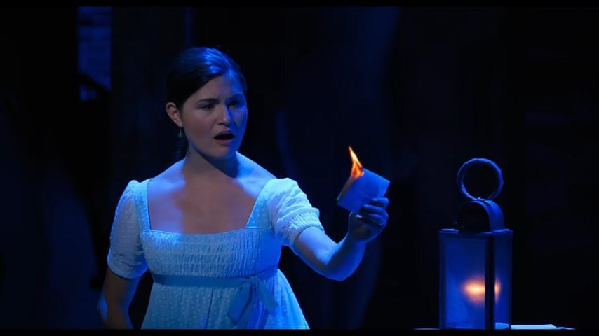 A still from the Hamilton pro shot. Phillipa Soo in her late 1700s style nightgown stands next to a lantern burning papers as she sings "Burn", a song about how she was betrayed by her husband's affair.